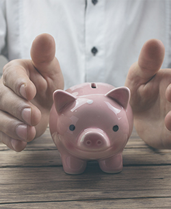 hands around a piggy bank